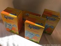 Four boxes of Swiffer Dusters in yellow packaging placed together. Each box states 10 dusters and Gain scent.