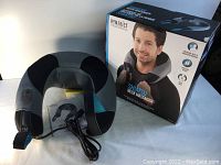 Photo showing neck massager and original box with branding and product features visible.