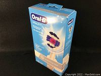 Front and side views of the blue box featuring Oral-B Vitality rechargeable electric toothbrush 3D White with round brush head, highlighting whitening and deep cleaning features.