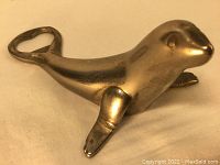 Side angle view showing the seal shape and bottle opener at the tail.