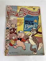 Front cover of the 1943 Looney Tunes Merrie Melodies comic showing Porky Pig and Bugs Bunny with helmets and a 'Buy War Bonds' war time message.