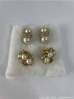 Both pairs of vintage Richelieu costume jewelry earrings displayed on white fabric showing overall design and condition.