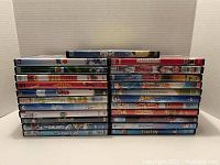 Photo showing a stack of 23 DVDs of animated and kids movies, visible titles include Epic, Rio, Free Birds, Fantastic Mr. Fox, Rango, Planet 51, The Smurfs series, Gnomeo & Juliet, The Adventures of Tintin.