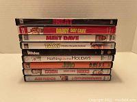 Photo showing a stack of 9 DVDs with titles from comedy movies.