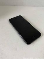 Front view of the Apple iPhone 5 Model A1428 showing the black screen and home button on a white surface.