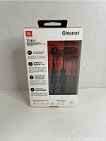 Back side of the sealed original JBL T110BT box showing product details, features like Pure Bass sound, 6 hours battery life, buttons for call and music control, and wireless Bluetooth capabilities.