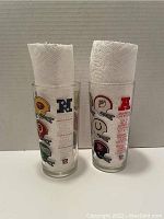 Front view of two NFL conference glasses with paper towels inside showing American Football Conference logos and helmets