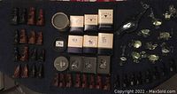 Chess set with carved animal pieces arranged on a dark surface along with boxed crystal figurines