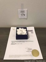 Ring in jewelry box displayed on appraisal certificate showing included documents and box