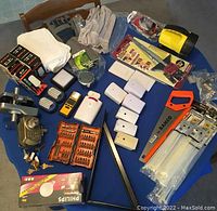 Full overview of the lot items on a table showing all tools, gloves, wall switches, screw bits and door locks