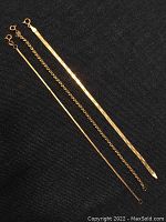 Three yellow gold bracelets laid flat showing full length and designs