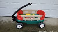 Side view of Little Tikes wagon with some toys inside showing colors and structure.