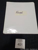 Closed white binder with Pokemon handwritten label on front cover