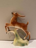 Front view of the leaping gazelle figurine showing whole figure on base