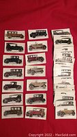 Complete set of 56 vintage tobacco cards laid out, showing detailed illustrations of early 20th century motor cars.