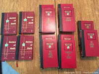 Ten red hardcover Christian Bernadac books with Nazi eagle emblem including Doctors of Death 1-4, The 186 Steps, The Ninth Circle, Doctors of Mercy, Otric's Doctors, and The Death Train, arranged on a wooden table.