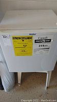 White Haier mini fridge with energy guide stickers on front.