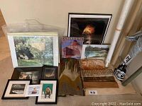 Overview photo showing framed art prints, Cunard Line poster, textile tapestries, and rolled canvas all grouped on floor.