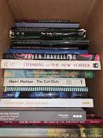 Box top view showing various coffee table books stacked inside, titles visible