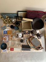 Full view of all lot items laid out, showing mugs, cast iron pieces, baskets, small decor items, and artwork
