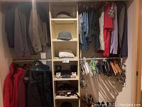 Full closet view showing hanging jackets, shirts, ties, hats, belts and shoes