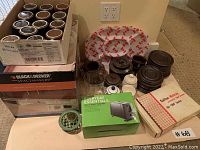 Boxed kitchenware including brown ceramic mugs and plates, teapots, and small boxed appliances