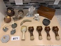 Overview photo showing all items on the counter including the owl, wooden box, pottery pieces, and white carved figurines.
