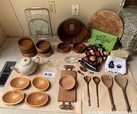 Overview of Pyrex glassware, wooden bowls and kitchen textiles arranged on floor.