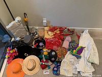 Full view of costumes, hats, masks, and accessories laid out on floor.