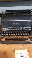 Front view of black Smith Corona manual typewriter with round keys and visible wear.