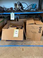 Five boxes with Star Trek books, one box open showing various books on a shelf next to power tools