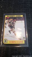 Front view of Bobby Orr hockey trading card showing the player in action with 'Scoring Leader' label and Boston Bruins logo.