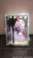 Front view of sealed hockey rookie card set showing card with player in white and blue uniform.