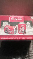 Photo of the original box showing Coca-Cola salt and pepper shakers shaped like soda cans with red and white branding.