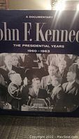 Front cover of the vinyl album, showing the title and a black and white photo of John F. Kennedy at a podium with others around him.