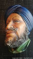 Side angle view of the Bossons ceramic head wall plaque, showing detailed facial features, textured beard, mustache, and blue turban.