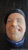 Frontal close-up image of the Bossons vintage sailor head wall plaque showing the winking face, black beret, blue sweater, and red pipe.