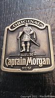 Close-up front view of the vintage Captain Morgan belt buckle showing detailed 3D figure and logo text.