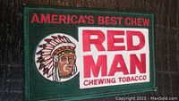 Front view of the rectangular embroidered fabric patch with 'RED MAN' chewing tobacco advertisement, Native American chief design, and slogan 'AMERICA'S BEST CHEW'.