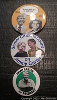 Photo showing three vintage Jimmy Carter 1976 political buttons with images and slogans