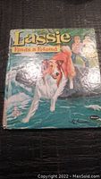 Front cover photo showing vintage Lassie children's book titled "Lassie Finds a Friend" with illustration of Lassie dog, two children and water scene.