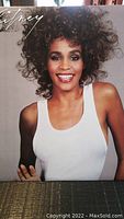 Front cover of the Whitney Houston vinyl album showing Whitney Houston wearing a white tank top and smiling with curly hair