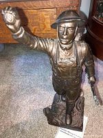 Front three-quarter view showing pose, rifle and raised arm