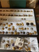 Display case of Civil War–era Union troop uniform buttons with hand-written labels identifying makers and locations