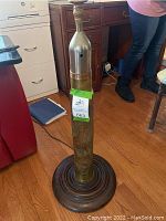 Tiered round wood base with bottom of brass shell casing