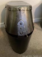 Frontal view of the full enclosed helm showing visor slit, perforated breathers, rivets and overall condition