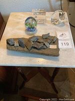 Small marble topped square accent table with turned wooden legs, holding paperweights on top