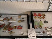 Overview of two black-framed displays showing multiple medals from various countries