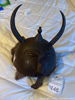 Full view of khula khud helmet showing horns, dome and chain mail aventail.