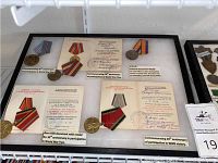 Four Soviet medals on display board, three with silk ribbon mounts
